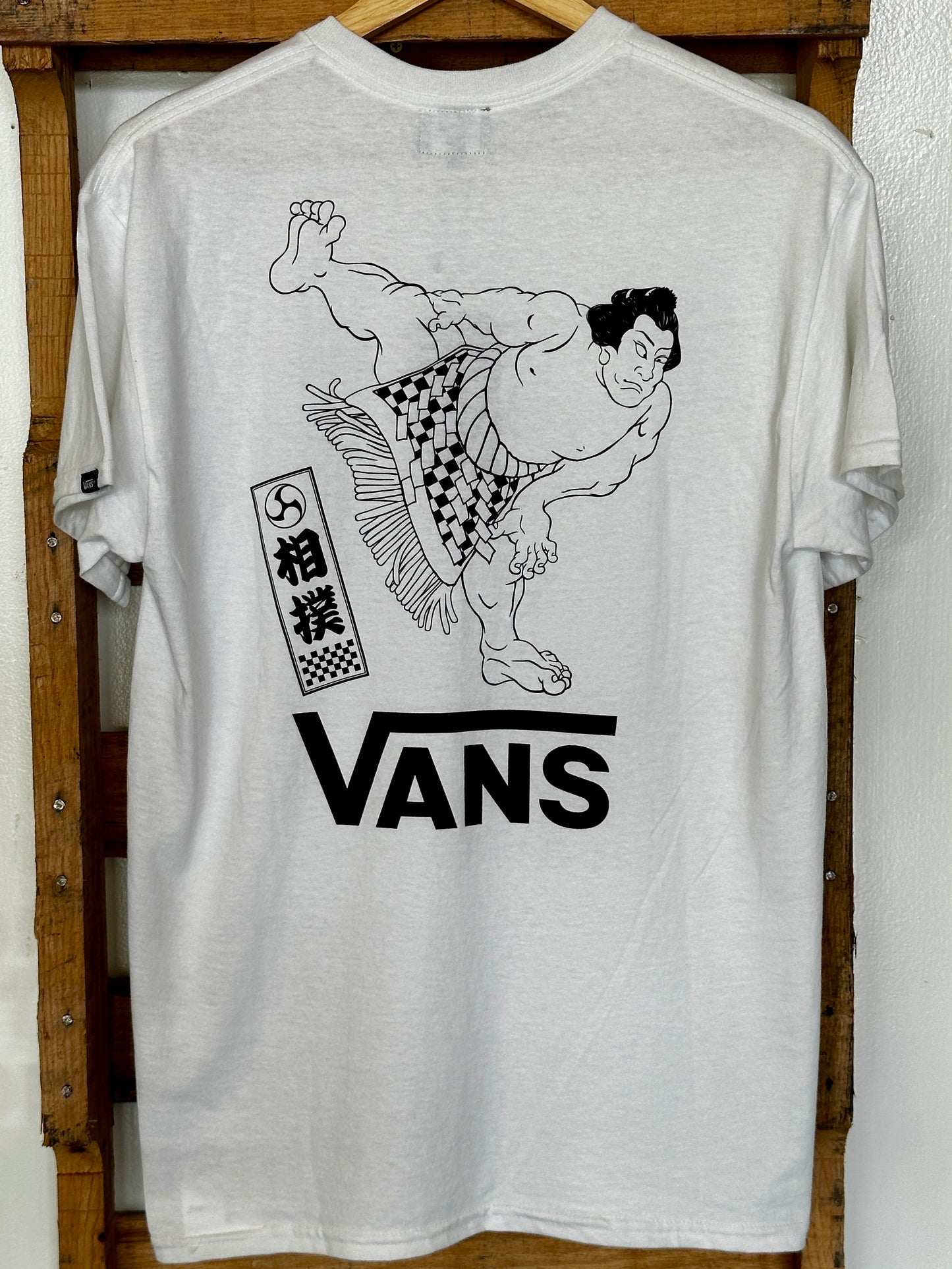 Vans Japan Limited T-shirt "Sumo"
The CULTURE TEE series, which incorporates VANS' signature checkerboard pattern and skate elements with motifs of Japanese culture, now introduces the 'Sumo' tee. The design features a dynamic graphic on the back print that catches the eye.
